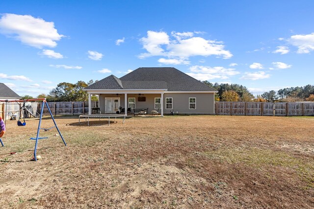 rear view of house with a trampoline, a playground, and ceiling fan