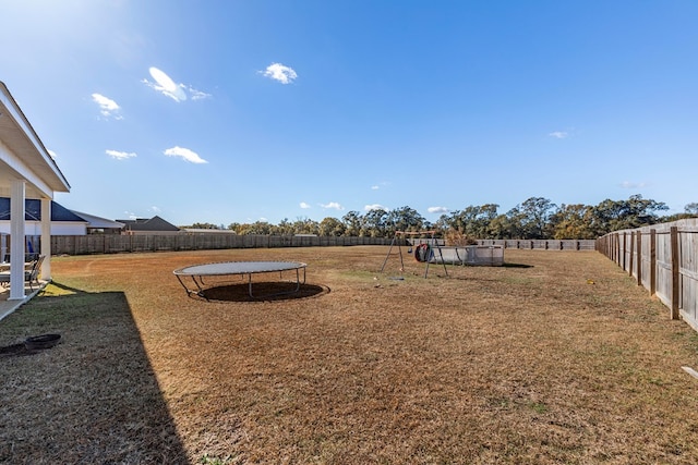 view of yard featuring a playground and a trampoline