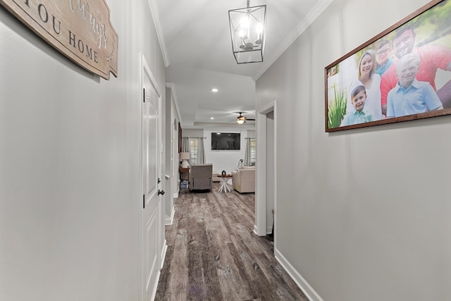 hallway featuring crown molding, dark hardwood / wood-style flooring, and a notable chandelier