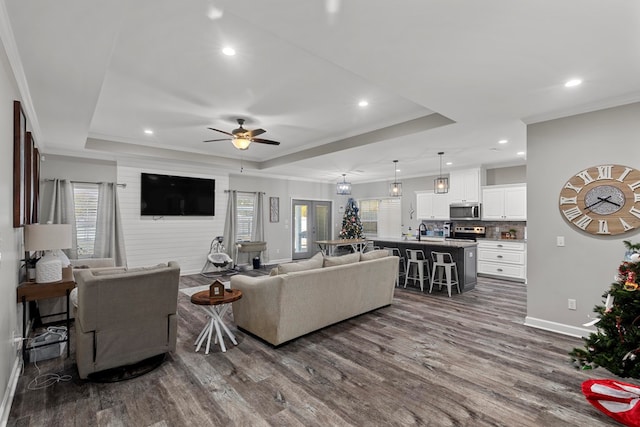 living room with crown molding, a wealth of natural light, dark wood-type flooring, and ceiling fan