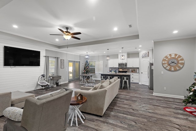 living room featuring ceiling fan, dark hardwood / wood-style floors, and ornamental molding