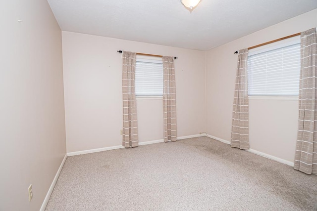 unfurnished room with baseboards and carpet floors