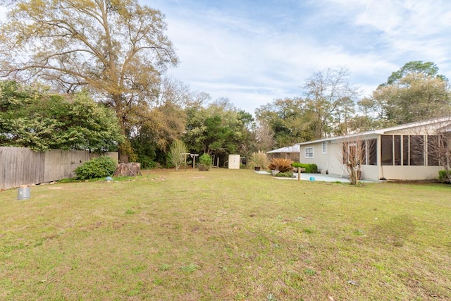view of yard with an outdoor structure, fence, and a shed