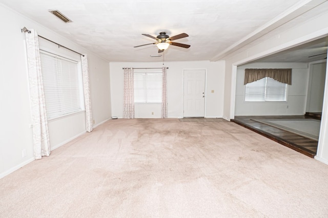 unfurnished living room featuring visible vents, carpet floors, baseboards, and ceiling fan