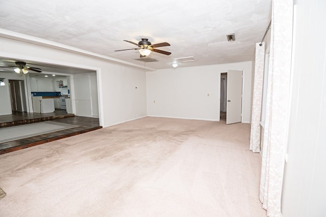 carpeted empty room with visible vents and ceiling fan