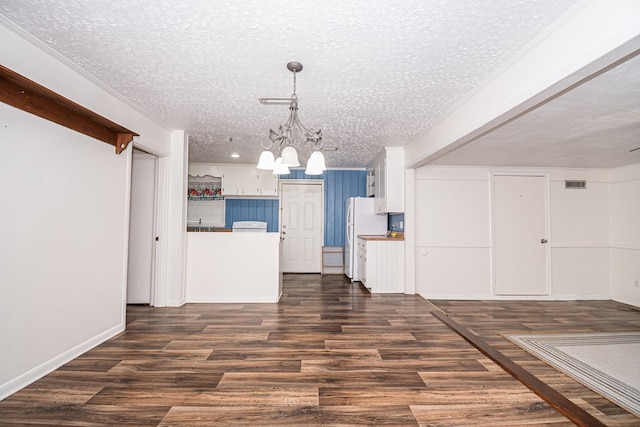kitchen featuring dark wood finished floors, white cabinets, a notable chandelier, and a textured ceiling