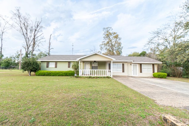 ranch-style home featuring driveway, covered porch, and a front yard