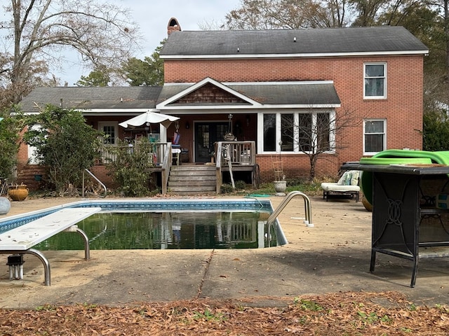 rear view of house featuring a pool side deck