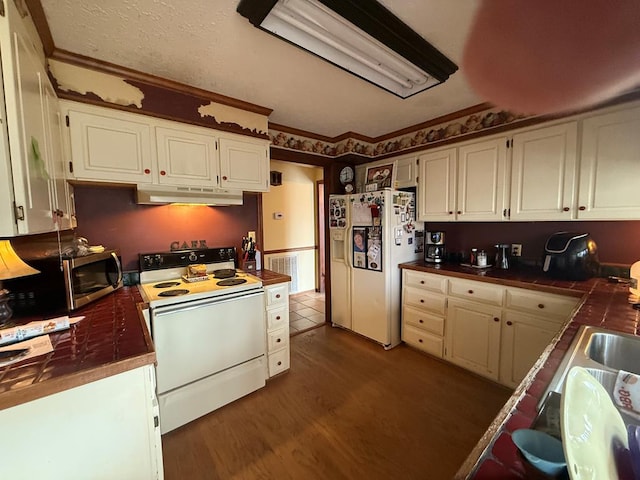 kitchen with crown molding, dark wood-type flooring, white cabinets, and white appliances