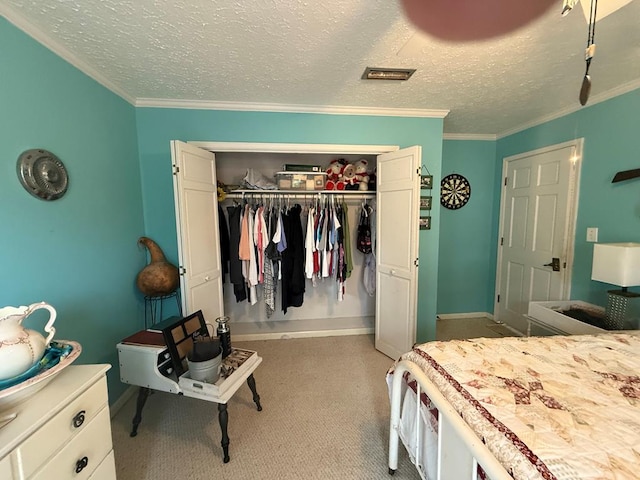 bedroom with crown molding, light colored carpet, a textured ceiling, and a closet