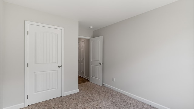 unfurnished bedroom with light carpet and a closet