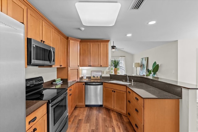 493 Shiloh Rd, Hartford, AL 36344 - kitchen featuring appliances with stainless steel finishes, light wood-style floors, a peninsula, dark stone counters, and recessed lighting