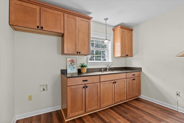 493 Shiloh Rd, Hartford, AL 36344 - kitchen featuring dark countertops, dark wood finished floors, decorative light fixtures, and brown cabinetry