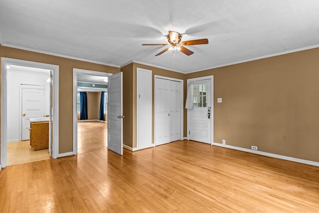 interior space with light wood-style flooring, baseboards, ornamental molding, and ceiling fan