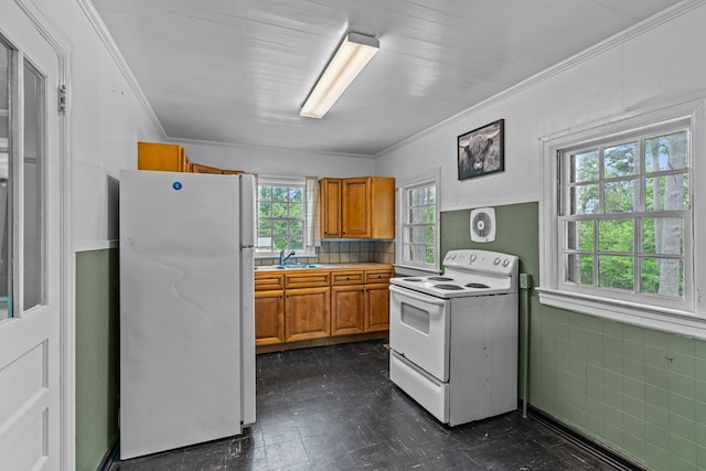 kitchen featuring white appliances, brown cabinets, ornamental molding, dark floors, and light countertops