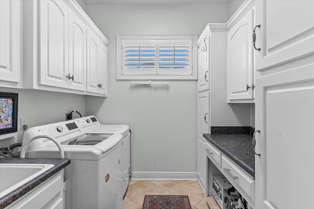 laundry room with light tile patterned floors, cabinet space, a sink, washer and dryer, and baseboards