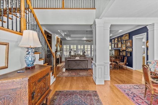 foyer entrance with ceiling fan, ornamental molding, wood finished floors, and decorative columns