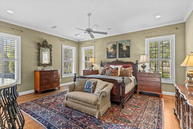 bedroom with light wood finished floors, multiple windows, and crown molding