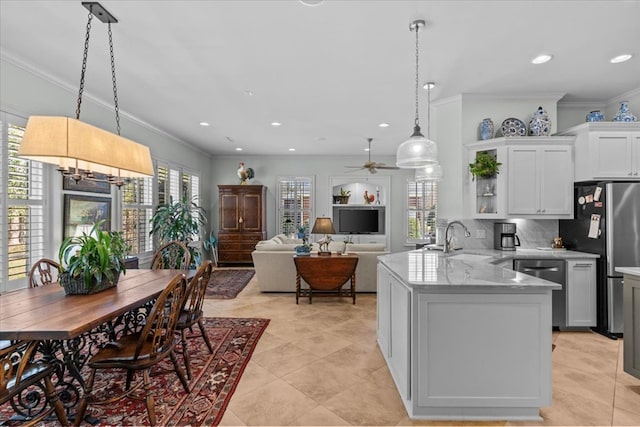 kitchen with stainless steel appliances, a sink, decorative backsplash, and ornamental molding