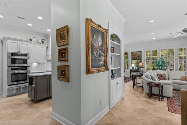 corridor featuring light tile patterned floors, recessed lighting, visible vents, ornamental molding, and baseboards