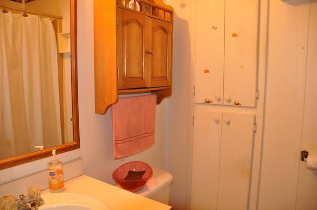 bathroom with a shower with shower curtain, toilet, and sink