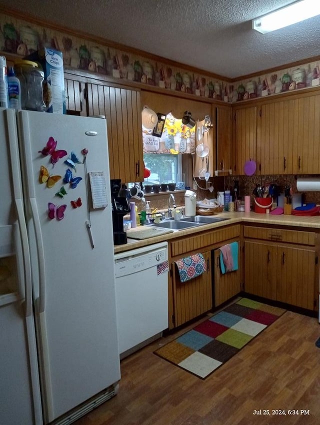 kitchen featuring tasteful backsplash, a textured ceiling, white appliances, dark wood-type flooring, and sink