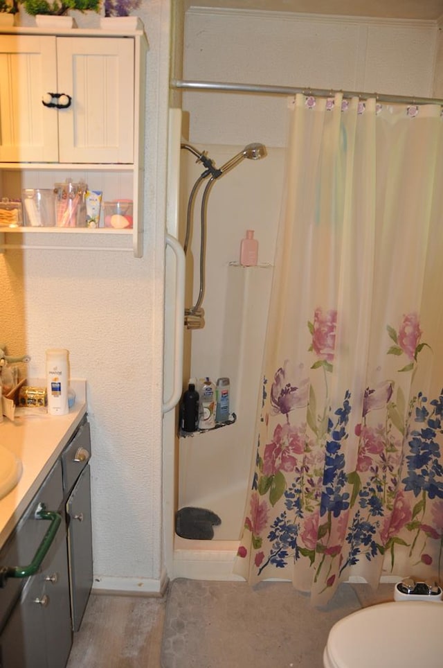 bathroom featuring a shower with shower curtain, vanity, and toilet