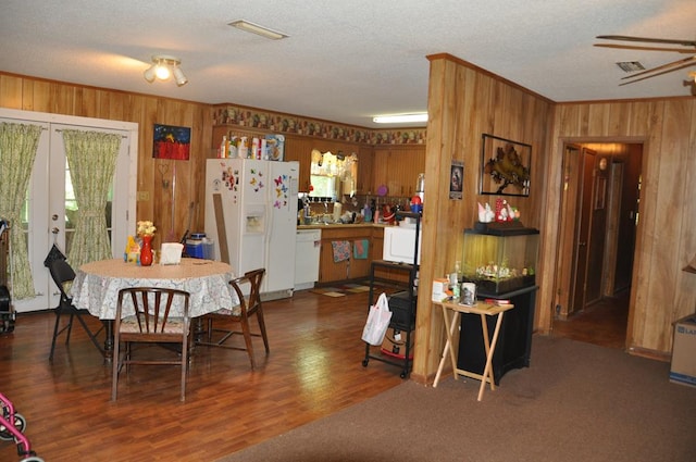 210 Anderson St, Kinston, AL 36453 - dining area featuring wood walls, french doors, plenty of natural light, a textured ceiling, and wood finished floors