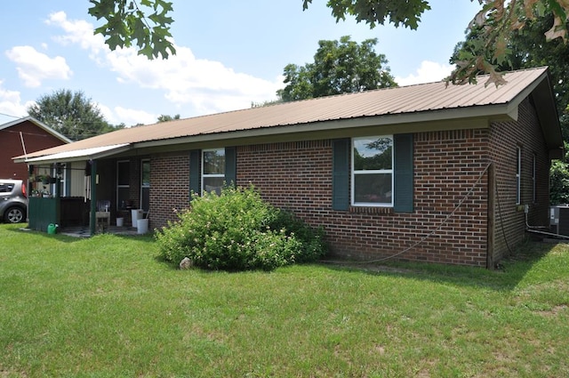 210 Anderson St, Kinston, AL 36453 - view of property exterior with a yard, brick siding, and a metal roof
