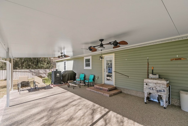 view of patio with area for grilling, fence, and a ceiling fan