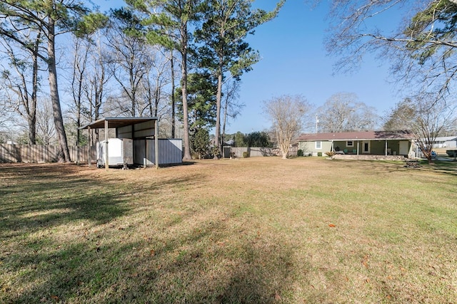 view of yard with fence and a carport