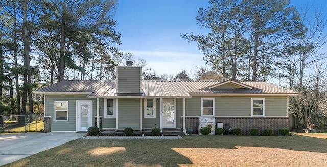 ranch-style home featuring brick siding, a chimney, metal roof, fence, and a front lawn