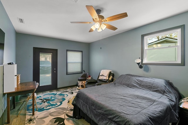 bedroom with baseboards, access to outside, visible vents, and a ceiling fan