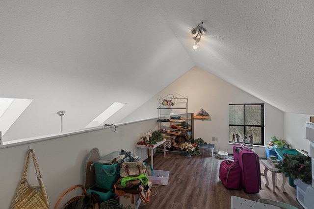 bonus room featuring a textured ceiling, lofted ceiling with skylight, and dark wood finished floors