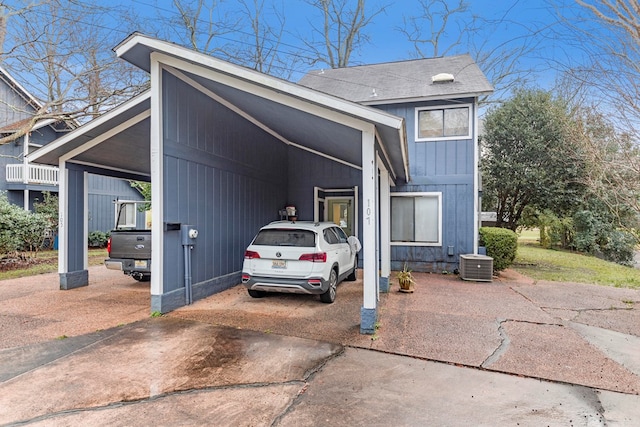 view of front facade featuring a shingled roof, central AC unit, and board and batten siding