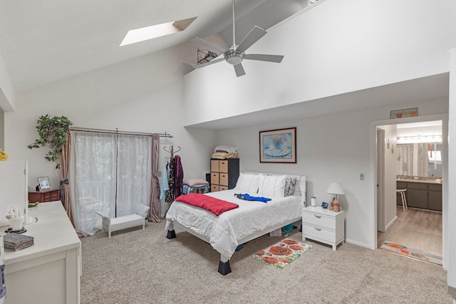 bedroom featuring a skylight, light carpet, ceiling fan, high vaulted ceiling, and baseboards