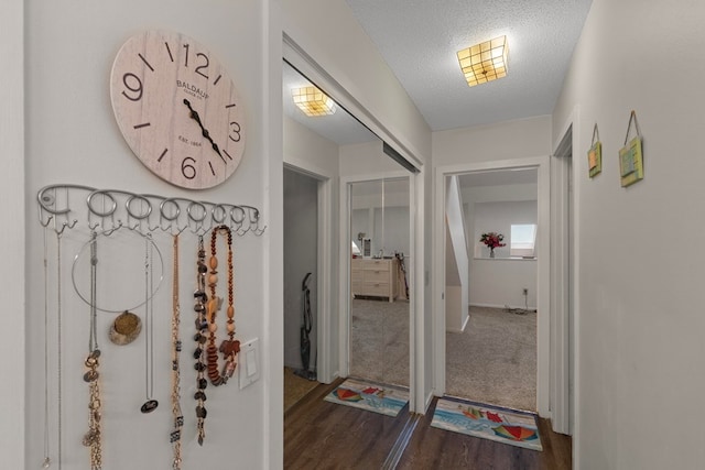 hall with dark wood finished floors and a textured ceiling