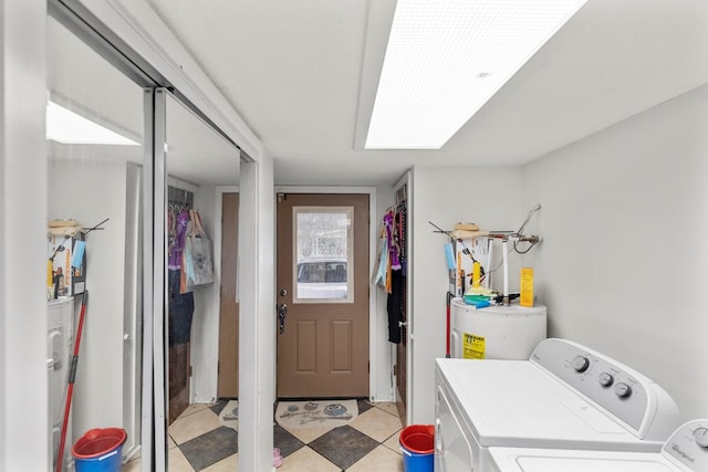 clothes washing area featuring laundry area, electric water heater, light floors, and independent washer and dryer