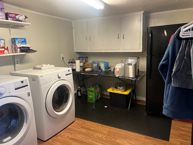 laundry room featuring light hardwood / wood-style floors, ornamental molding, and washing machine and clothes dryer