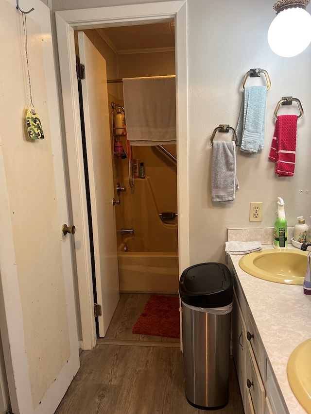 bathroom featuring ornamental molding, vanity, wood-type flooring, and tub / shower combination