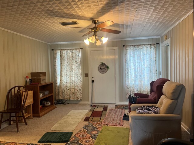 carpeted living room featuring ceiling fan and ornamental molding