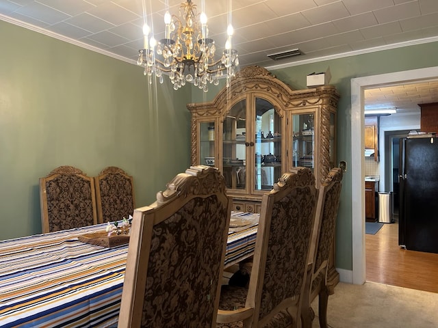 carpeted dining space featuring crown molding and a notable chandelier