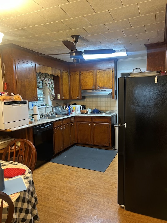 kitchen with black appliances, ceiling fan, light hardwood / wood-style floors, and backsplash