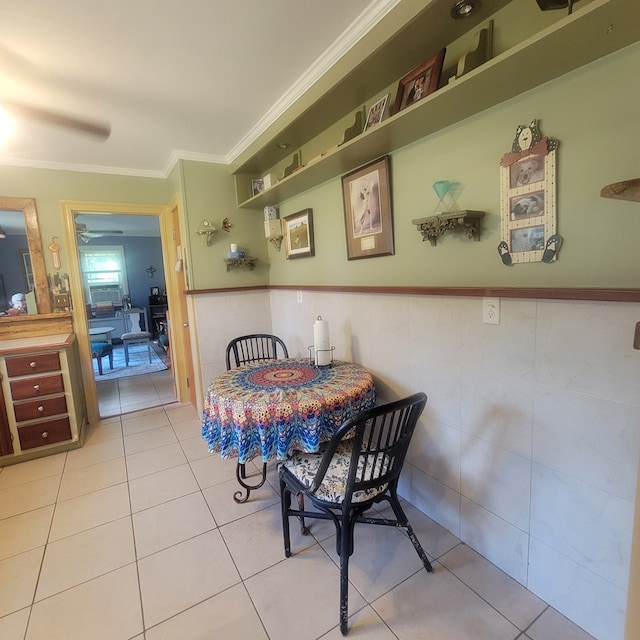 tiled dining area featuring ceiling fan and ornamental molding