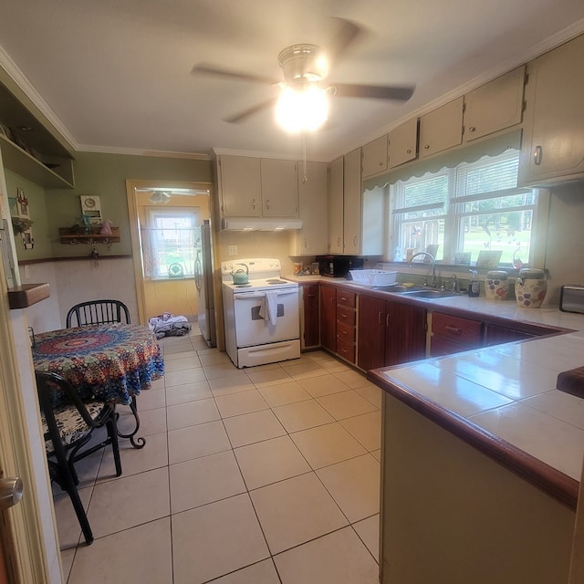 kitchen featuring cream cabinetry, white electric range oven, a healthy amount of sunlight, and sink