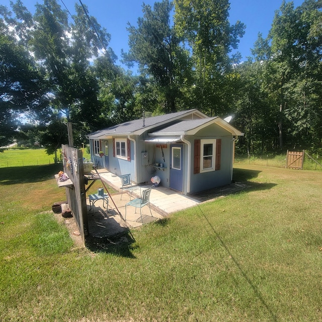 rear view of house with a patio and a lawn