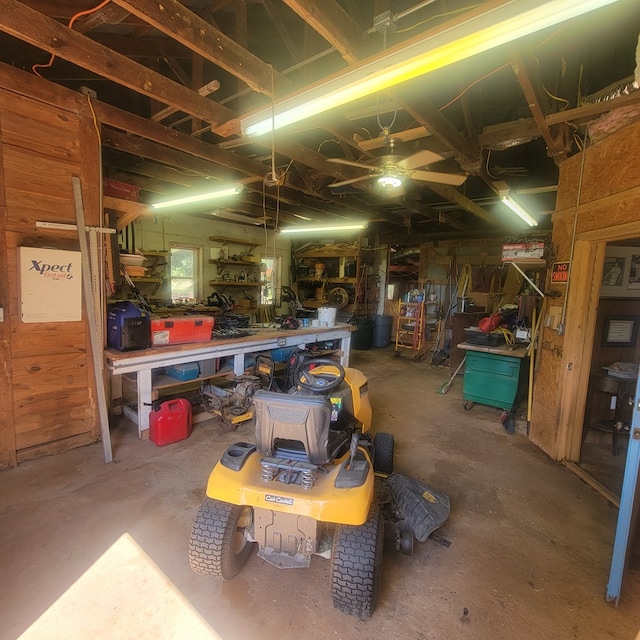 garage with a workshop area and wood walls