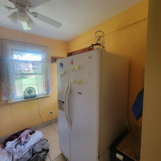 interior space featuring ceiling fan, light tile patterned floors, and white refrigerator with ice dispenser