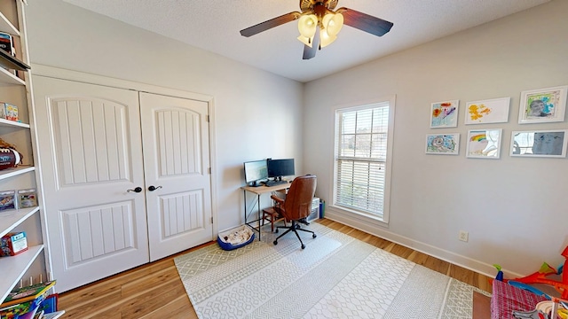 office with a ceiling fan, a textured ceiling, baseboards, and wood finished floors