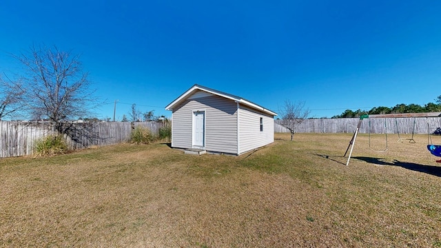 view of outdoor structure with a fenced backyard, an outdoor structure, and a playground